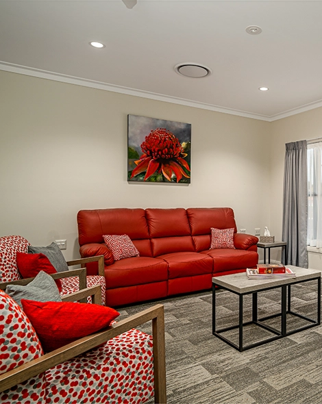 Image of a living area showing red lounges and paintings